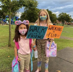 Two children holding signs for walk to school day.