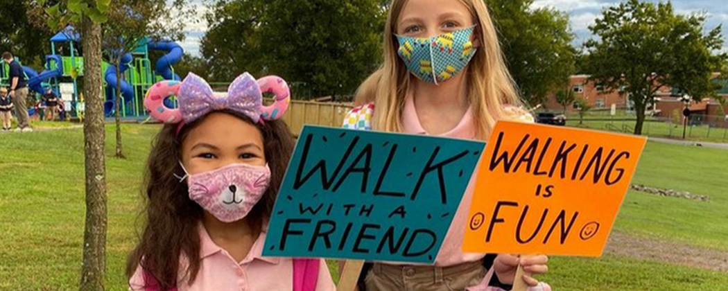 Two children holding signs for walk to school day.