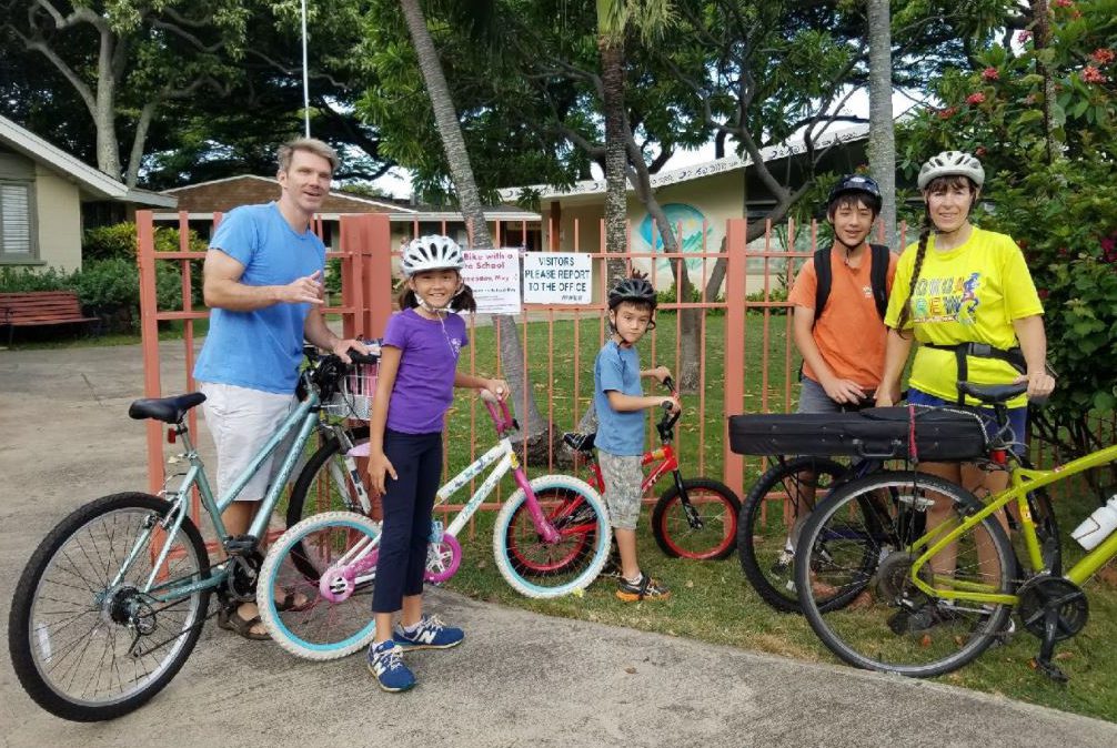 A small group of children and adults gather with their bikes.